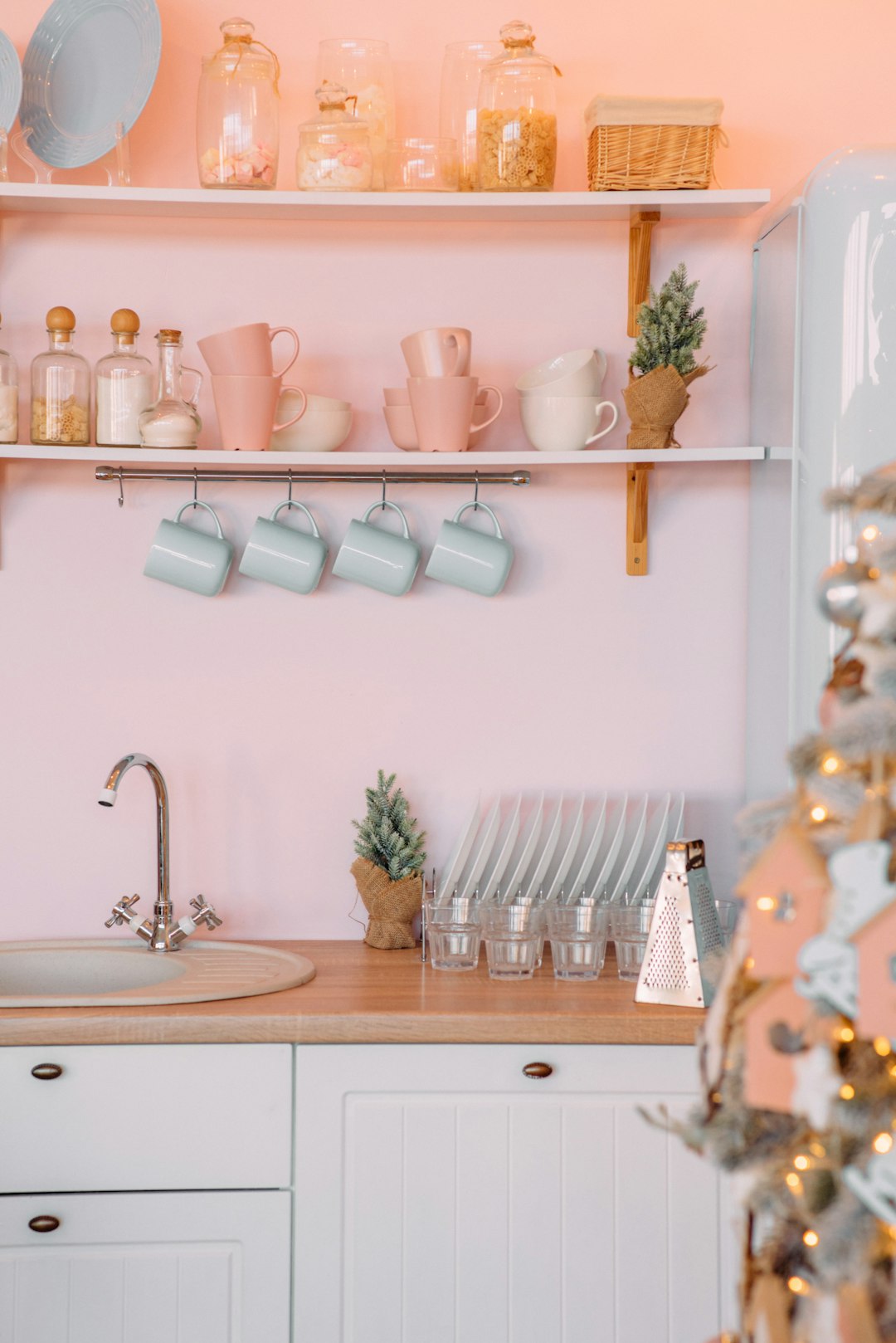 a-kitchen-with-pink-walls-and-white-cabinets-t598cvf6buc